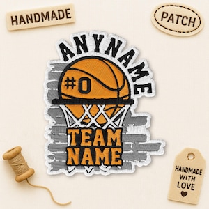 May include: Embroidered basketball patch with the text "ANYNAME" above an orange basketball with the number "0" and a net. Below the net is the text "TEAM NAME". The patch is on a light beige background.