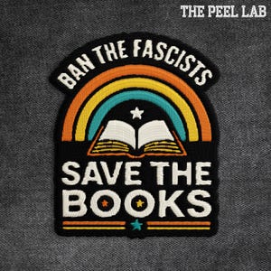 May include: Embroidered patch with the text "BAN THE FASCISTS" above a rainbow and an open book, with "SAVE THE BOOKS" below. The patch is black with white, orange, yellow, and teal details. The Peel Lab logo is in the top right corner.