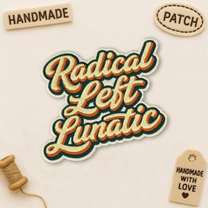 May include: Embroidered patch with the words "Radical Left Lunatic" in orange and cream-coloured lettering with a dark teal outline. The patch is surrounded by a dark teal border. Additional tags read "Handmade", "Patch", and "Handmade with Love".
