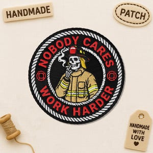 May include: Embroidered patch featuring a skeleton firefighter smoking a cigarette. The patch is black with white rope edging and the words "NOBODY CARES WORK HARDER". Includes "HANDMADE" and "PATCH" tags.