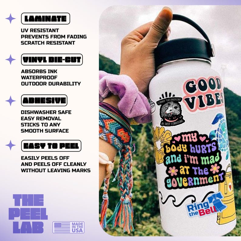 May include: A white water bottle covered in colorful stickers, including one that says "GOOD VIBES." Other stickers read "my body hurts and I'm mad at The government." The bottle is held by a person wearing a bracelet. The Peel Lab stickers are also visible.
