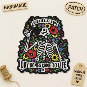 May include: An embroidered patch featuring a white skeleton surrounded by colorful red, yellow, purple, and blue flowers. The top banner reads EZEKIEL 37:1-10 and the bottom banner reads DRY BONES COME TO LIFE in black lettering on a white background.