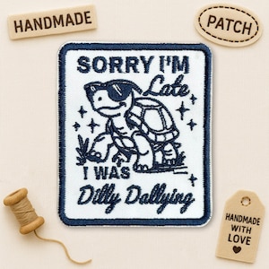 May include: Embroidered patch with a navy blue border and a white background. The patch features a cartoon turtle wearing sunglasses with the text "SORRY I'M Late I WAS Dilly Dallying". Additional tags read "HANDMADE", "PATCH", and "HANDMADE WITH LOVE".