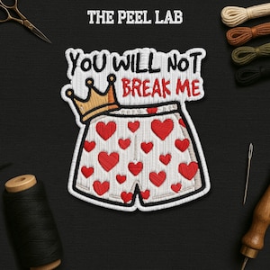 May include: Embroidered patch showing white shorts with red hearts and a gold crown. The text "YOU WILL NOT BREAK ME" is above the shorts. The Peel Lab logo is at the top.
