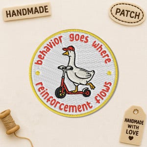 May include: Embroidered patch featuring a goose riding a red scooter, wearing a red cap. The patch has a yellow border with the text "behavior goes where reinforcement flows". Additional tags read "Handmade" and "Patch".