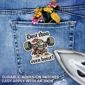 Puede incluir: Parche bordado con un caballero de dibujos animados levantando pesas, con el texto "Dost thou even hoist?" en una fuente medieval. El parche est&aacute; sobre un fondo de mezclilla azul, con un bolsillo que contiene flores. Se ve una plancha.