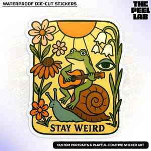 May include: A die-cut sticker featuring a green frog playing a guitar while riding a snail. The sticker has a yellow background with flowers, a sun, and the text "STAY WEIRD". The sticker is labeled "WATERPROOF DIE-CUT STICKERS".