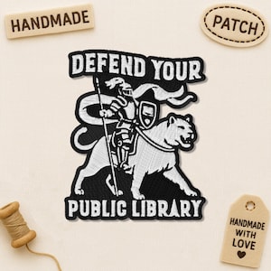 May include: Embroidered patch with a black and white design of a knight on a lion, with the text "DEFEND YOUR PUBLIC LIBRARY." Includes a "PATCH" and "HANDMADE" tag.