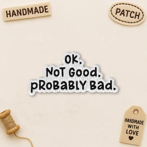 Peut inclure: Ensemble d'articles de loisirs créatifs faits à la main. Comprend un écusson, une bobine de fil et des étiquettes avec les mentions "HANDMADE" et "HANDMADE WITH LOVE". Un autocollant argenté et blanc indique "Ok. Not Good. Probably Bad."