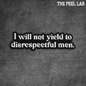 May include: A black and white embroidered patch with the text "I will not yield to disrespectful men." The patch is rectangular with a black border and is set against a gray, textured background. The text "THE PEEL LAB" is at the top.