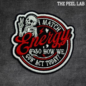 May include: Embroidered patch with a black background, red text, and a white border. The patch features a skeleton giving a peace sign and the words "I MATCH ENERGY SO HOW WE GON' ACT TODAY?" The Peel Lab logo is in the top right corner.