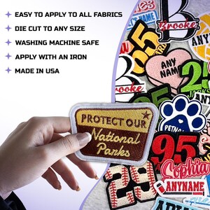 May include: A collection of embroidered patches with various designs and text. One patch reads "PROTECT OUR National Parks". Other patches include the text "ANY NAME", "95", and "Sophia". The image also includes text: "EASY TO APPLY TO ALL FABRICS", "DIE CUT TO ANY SIZE", "WASHING MACHINE SAFE", "APPLY WITH AN IRON", and "MADE IN USA".