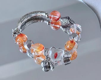 Pulsera de cuarzo fuego con flor roja, dije de manzana de cristal llamativo y detalles de hoja plateada.