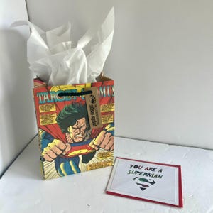 Sacola de presente e cartão comemorativo da história em quadrinhos do Superman