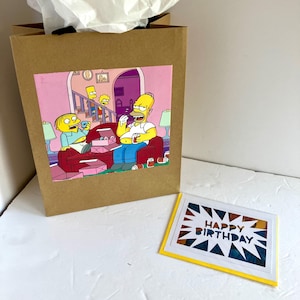 Sacola de presente e cartão comemorativo da revista em quadrinhos dos Simpsons