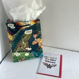 Sacola de presente e cartão comemorativo da história em quadrinhos da Mulher-Maravilha