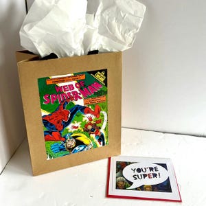 Sacola de presente e cartão comemorativo da história em quadrinhos do Homem-Aranha