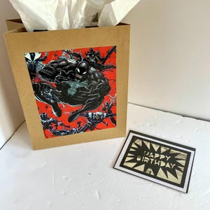 Sacola de presente e cartão comemorativo do livro Carnage Venom