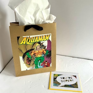 Sacola de presente e cartão comemorativo da revista em quadrinhos Aquaman