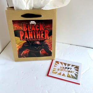 Sacola de presente e cartão comemorativo da história em quadrinhos do Pantera Negra