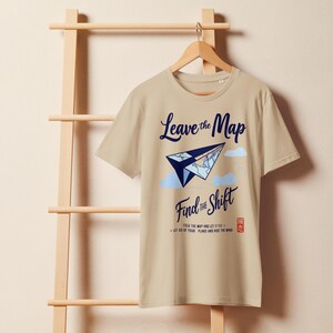Landkarte hinterlassen. Finde die Schicht.Dieses minimalistische himmelblaue T-Shirt zeigt einen Papierflieger, der in deine nächste Schicht aufsteigt , ein organisches, mittelhelles T-Shirt