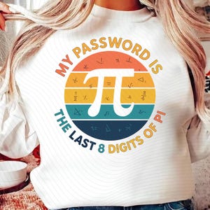May include: White sweatshirt with a colorful graphic. The graphic features a circle with the pi symbol and the text "MY PASSWORD IS THE LAST 8 DIGITS OF PI". The circle has orange, yellow, and blue stripes.