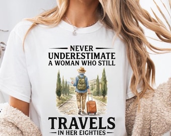 Nunca subestimes a una mujer que todavía viaja a sus ochenta años. Camiseta para abuela viajera. Regalo divertido para viajeros mayores. Camiseta para amantes de la aventura.
