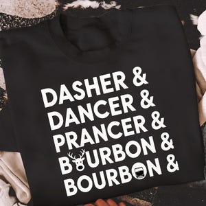 May include: Black sweatshirt with white text listing "Dasher & Dancer & Prancer & Bourbon & Bourbon &" with a reindeer graphic and a whiskey glass graphic. The sweatshirt is a crew neck.