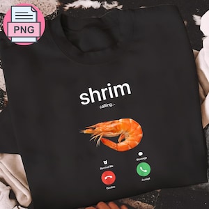 May include: Black sweatshirt featuring the text "shrim calling..." and a cooked shrimp image. The design includes a phone interface with "Decline" and "Accept" buttons.