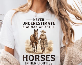 Onderschat nooit een vrouw die nog steeds paarden in haar jaren tachtig Shirt, grappig T-shirt paardenliefhebber, cadeau senior cowgirl, T-shirt paardensport oma