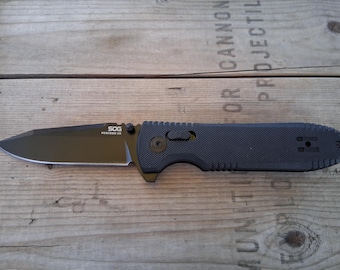 SOG pentagon folding knife in box coyote black scales