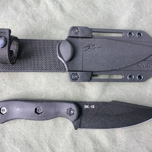 May include: A black Ka-Bar BK-18 knife with a matching sheath and belt loop. The knife has a black handle and blade, with the text "BK-18" printed on the blade. The sheath has the text "KA-BAR" printed on it.