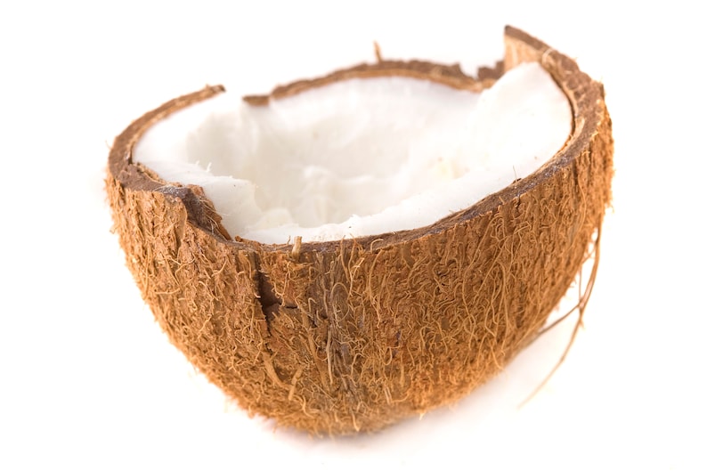 Peut inclure: Une moiti&eacute; de coque de noix de coco brune avec la chair de noix de coco blanche &agrave; l'int&eacute;rieur. La noix de coco est pos&eacute;e sur un fond blanc.