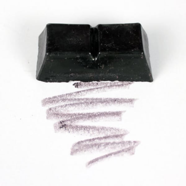 May include: A black rectangular block of charcoal for drawing, with a line of charcoal drawn on a white surface.
