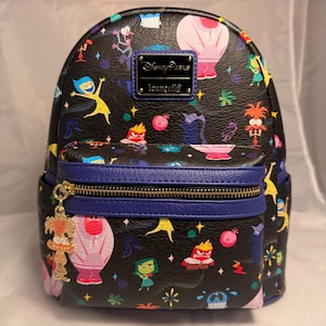 Può includere: Mini zaino nero con un motivo colorato con personaggi del film "Inside Out". Lo zaino ha una cerniera e finiture blu, un tirazip dorato e un logo "Disney Parks Loungefly".