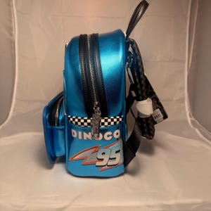 May include: A white ceramic mug with a black handle and the text "But First, Coffee" in a black, handwritten-style font. The mug is on a white surface.