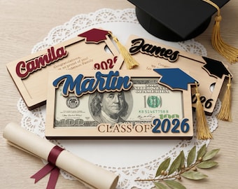 Puede incluir: Un juego de regalo de graduación con marcos de madera con nombres y birretes, un diploma enrollado y un billete de 100 $. Los marcos muestran los nombres "Camila", "James" y "Martin", con el texto "Class of 2026".