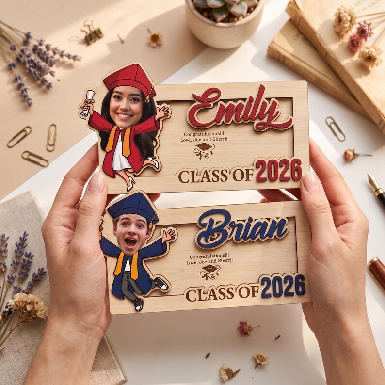 May include: Two wooden graduation frames with custom cartoon portraits. The top frame says "Emily" in red script, "Class of 2026" in red, and "Congratulations!!! Love, Joe and Sherril". The bottom frame says "Brian" in blue script and "Class of 2026" in blue.