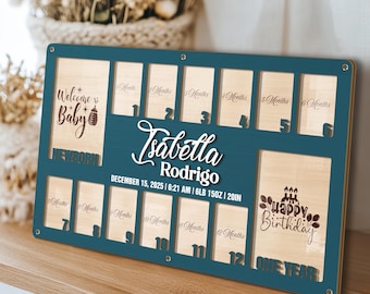 May include: A teal and wood-toned baby milestone board with spaces for photos. The board includes the text "Welcome Baby", the baby's name, birthdate, and weight. It also has spaces for photos from newborn to one year.