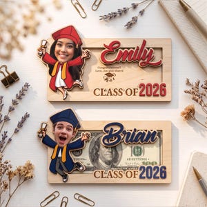 May include: Two wooden graduation frames with cartoon figures. One frame says "Emily" and "Class of 2026" with a cartoon figure in a red cap and gown. The other frame says "Brian" and "Class of 2026" with a cartoon figure in a blue cap and gown.