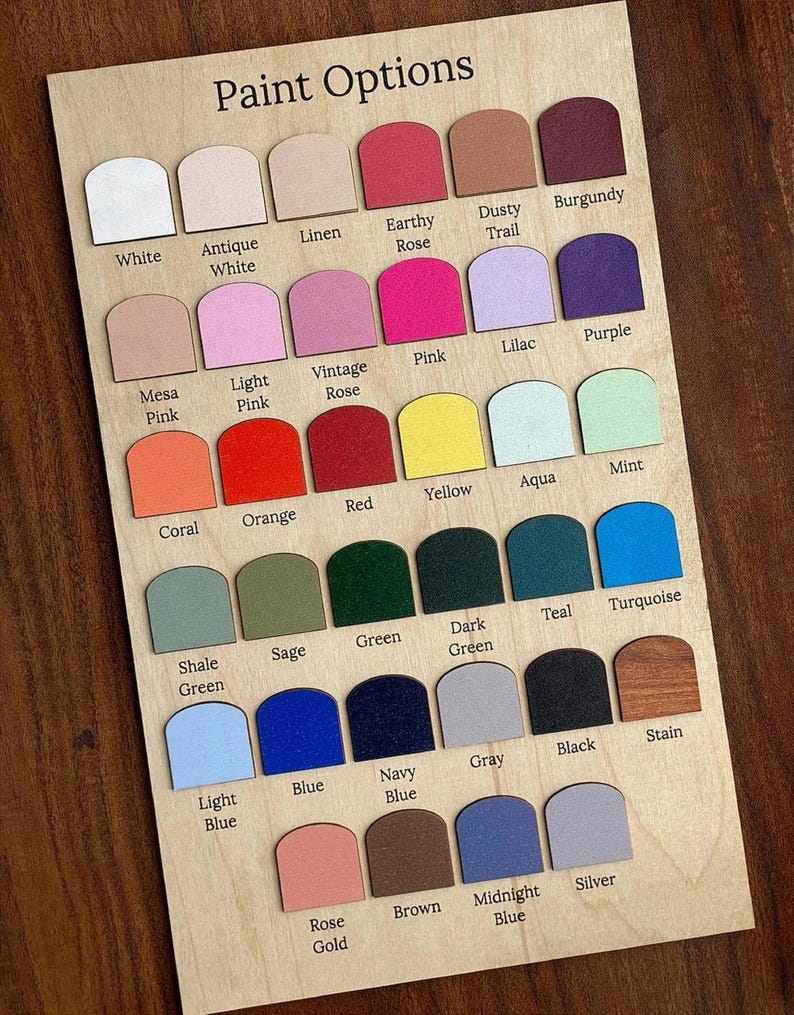 May include: Wooden paint color chart with the text "Paint Options." The chart displays a variety of paint colors, including white, pink, blue, green, and brown. Each color is labeled with its name, such as "White," "Pink," and "Blue."