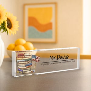 A clear glass block with a picture of a stack of books and an American flag, along with the name "Mr. Davis" and the phrase "Exploring the world, one timeline at a time".