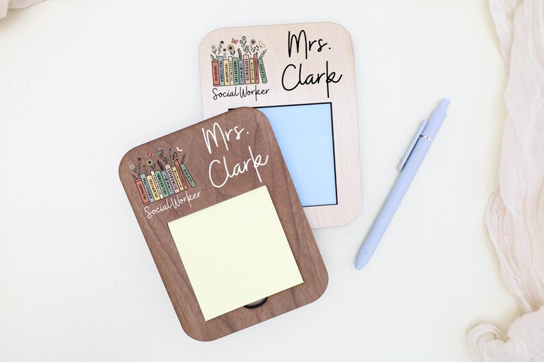 two wooden name cards, each with a name written on it, and a pen is placed next to them.