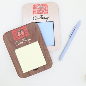 May include: Two wooden memo holders, one with a notepad and the other with a blue background. Both have the text "Respiratory Therapist" and a cartoon lung design. The name "Courtney" is written below the text. A light blue pen is also present.