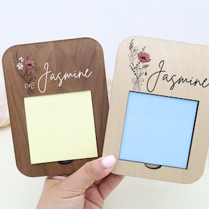 May include: Two wooden memo holders, one dark brown and one light, each with a floral design and the name "Jasmine" in script. The dark brown holder has a yellow note, while the light one has a blue note.