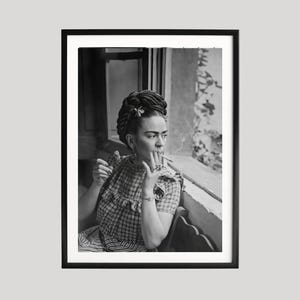 Pu&ograve; includere: Stampa incorniciata in bianco e nero di una donna con i capelli scuri, che indossa un abito a fantasia, fuma una sigaretta e guarda fuori da una finestra. L'immagine &egrave; un ritratto, con il soggetto seduto e lo sfondo sfocato.