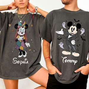 May include: Two charcoal gray t-shirts featuring Disney characters. The left shirt displays Minnie Mouse in a patchwork dress with the name Sophia. The right shirt shows Mickey Mouse in a pinstripe suit with ghosts and bats, labeled Tommy.