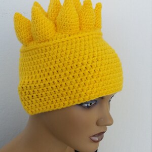Puede incluir: Un gorro de punto amarillo con un dise&ntilde;o &uacute;nico de p&uacute;as. El gorro est&aacute; hecho con un hilo suave y texturizado y tiene un ajuste c&oacute;modo.