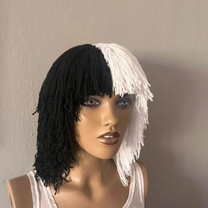 Könnte beinhalten: Ein schwarz-weißer Bob-Perücke. Die Perücke ist in zwei Hälften geteilt, eine Seite schwarz und die andere weiß. Sie ist auf einem Schaufensterpuppenkopf ausgestellt, der ein weißes Tanktop trägt.