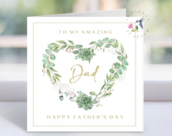 May include: A white Father's Day card with a gold border. The card features a heart-shaped wreath of green leaves and succulents around the word "Dad" in gold script. The text "To My Amazing" and "Happy Father's Day" are also in gold.